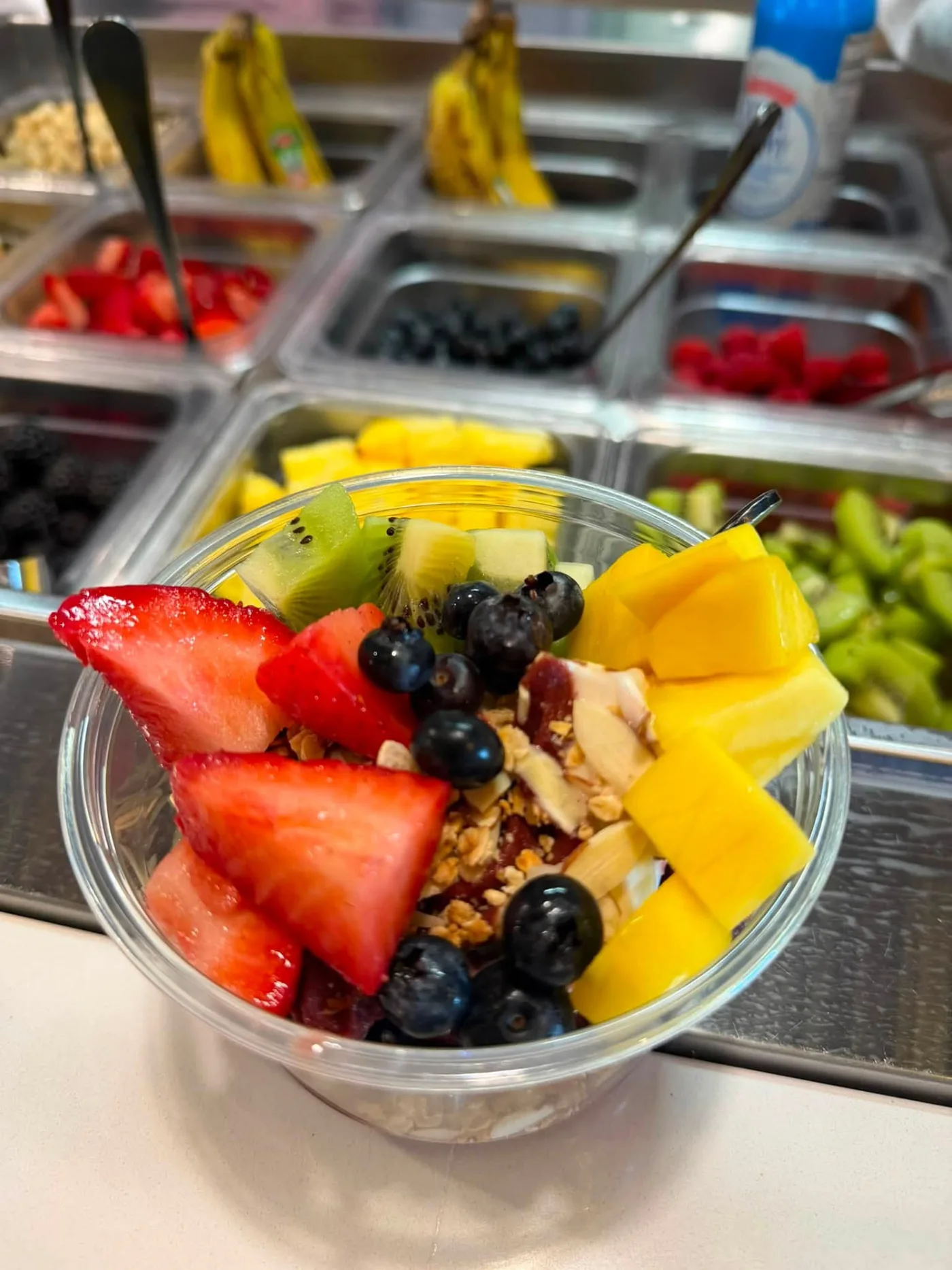 Açaí bowl topped with strawberries, blueberries, kiwi, mango and granola at the AMI FroYo fruit bar